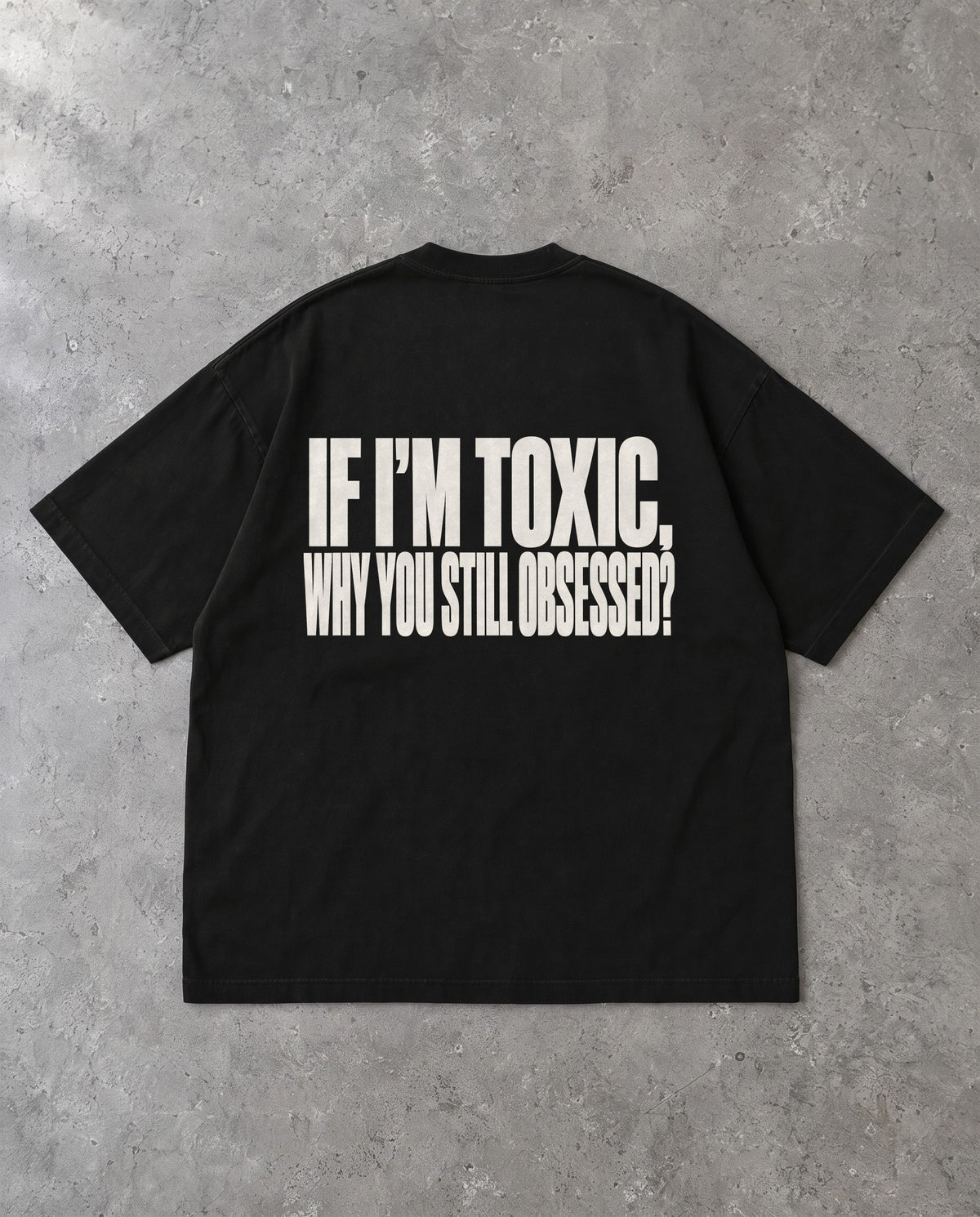 STILL OBSESSED — Oversized Tee in Black, Rückenprint, Flat-Lay