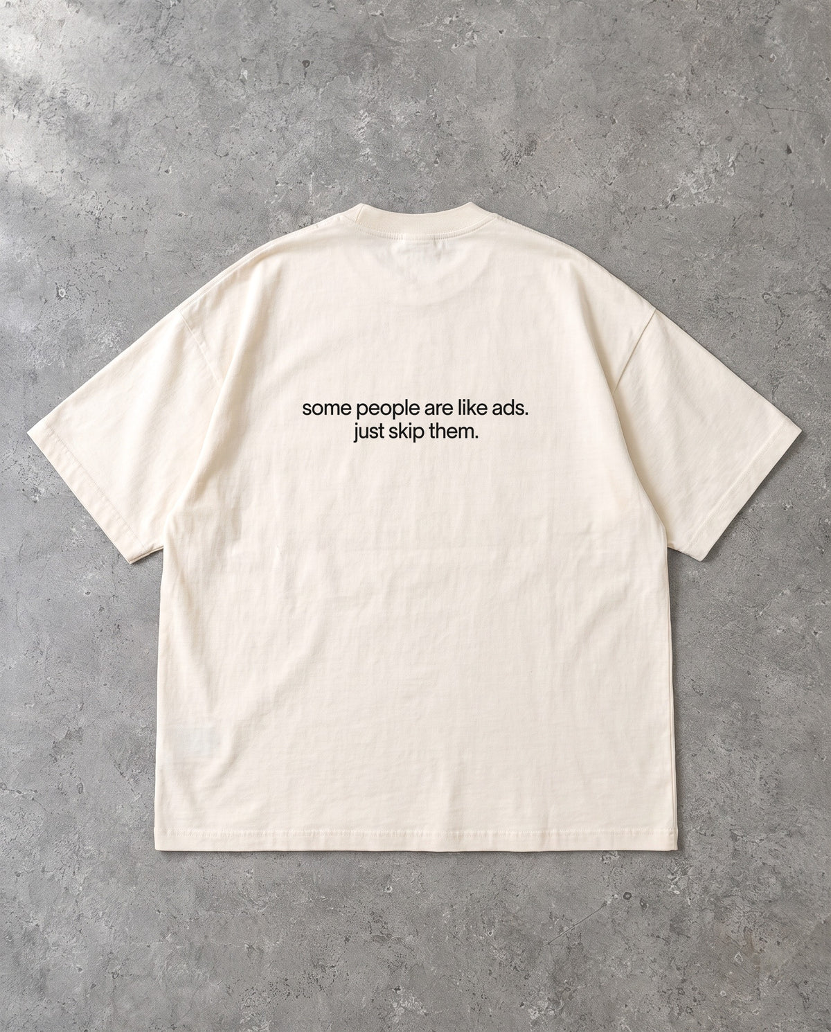 SKIP THEM — Oversized Tee in Natural Raw, Rückenprint, Flat-Lay