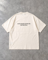 SKIP THEM — Oversized Tee in Natural Raw, Rückenprint, Flat-Lay