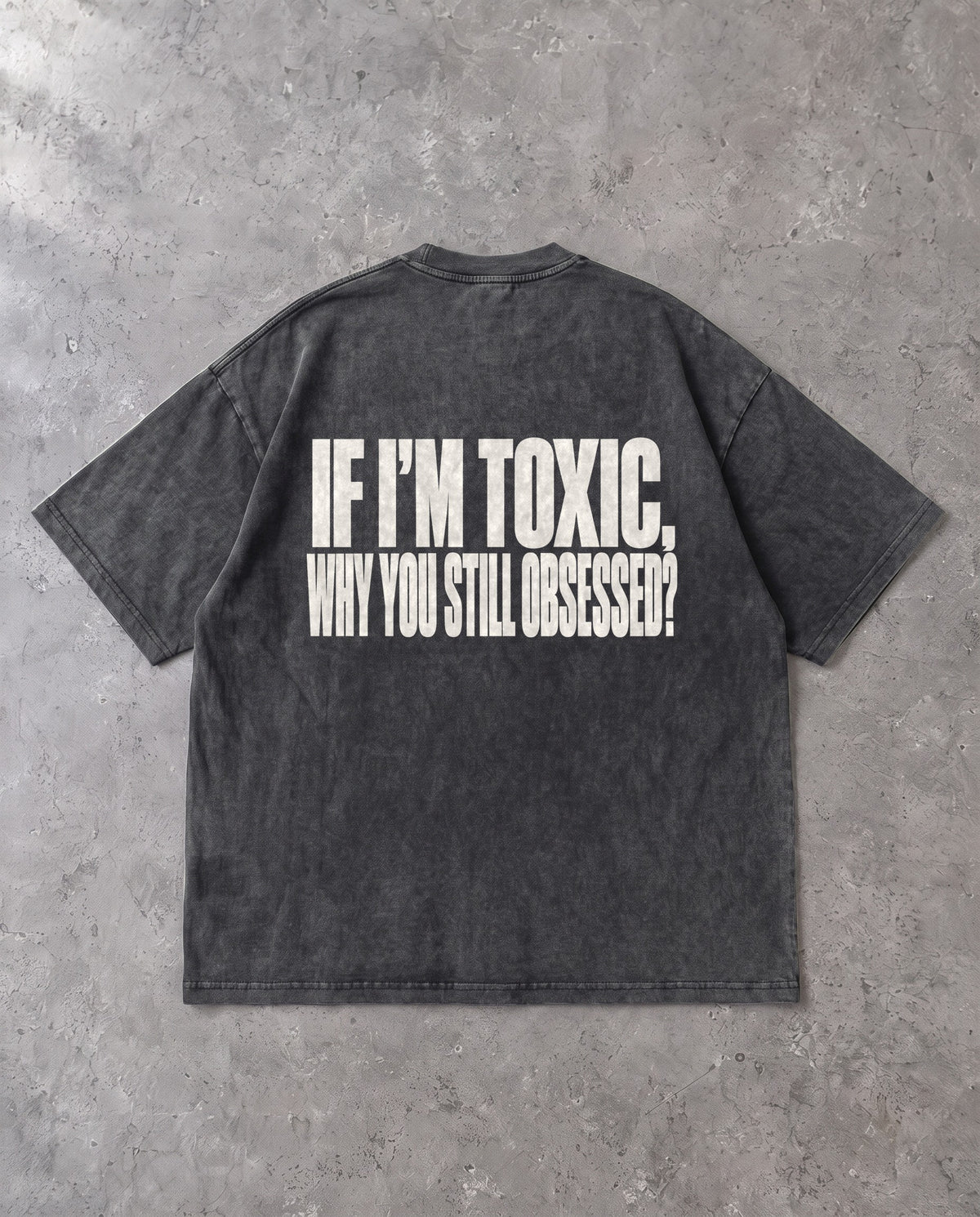 STILL OBSESSED — Oversized Tee in Washed Black, Rückenprint, Flat-Lay