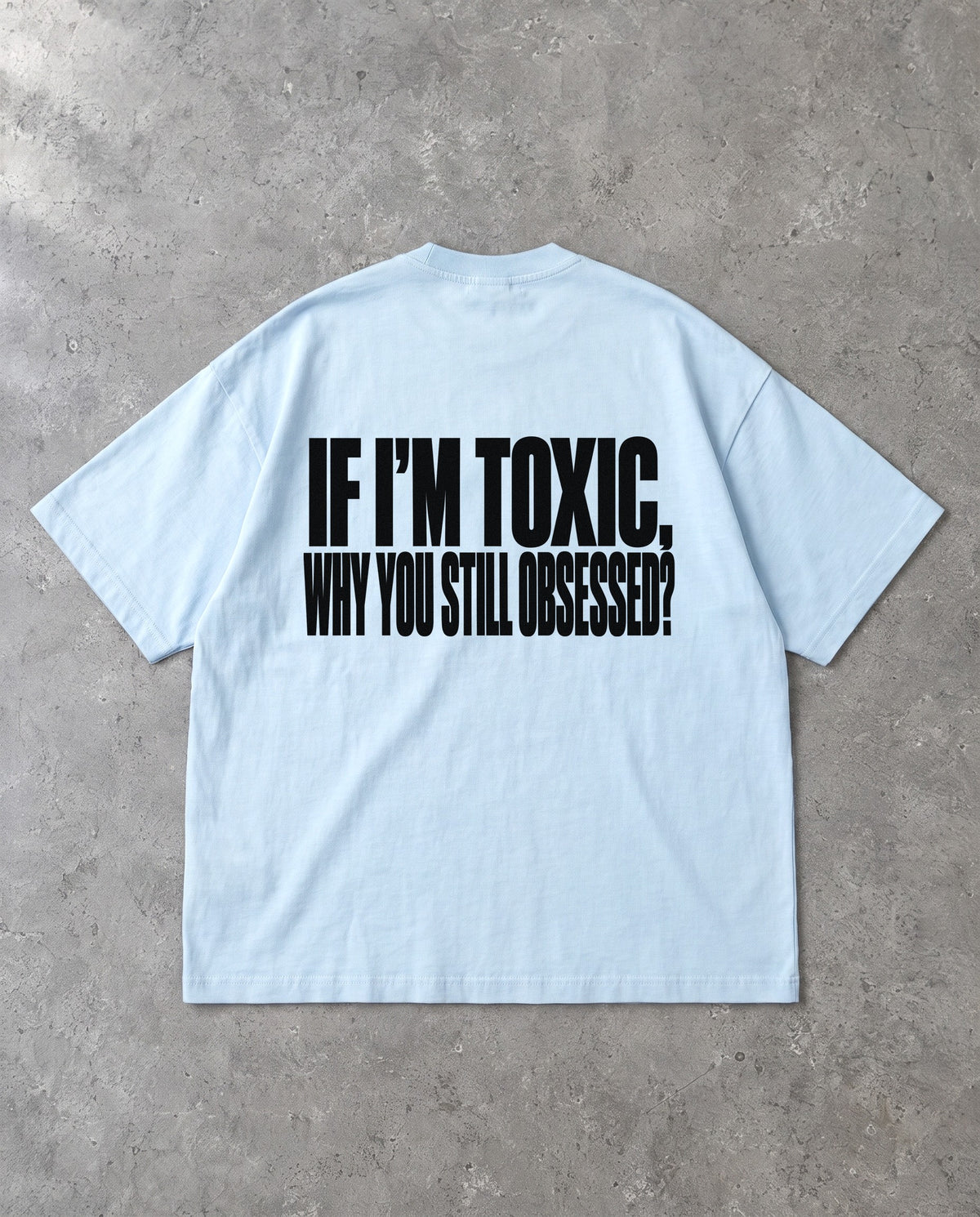 STILL OBSESSED — Oversized Tee in Baby Blue, Rückenprint, Flat-Lay
